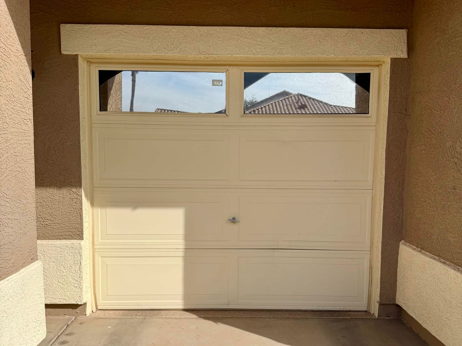 After: the same single-car garage door reset onto its track and closed square in the opening in Mesa