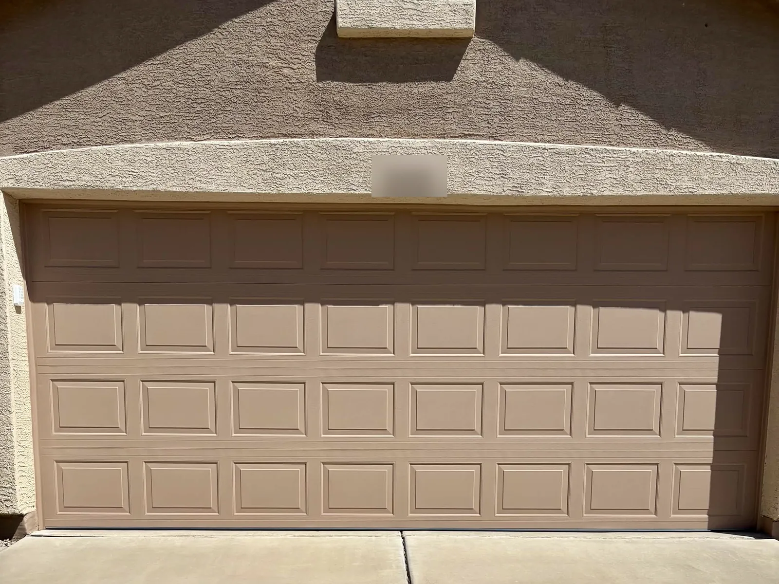 After: new insulated tan raised-panel double garage door that matches the stucco trim in Mesa